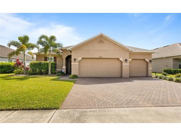 Charming single-story home featuring a brick driveway and lush green lawn with landscaping at 3936 Parkhouse Dr, Orlando, FL 32824