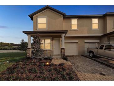 Charming townhouse featuring a brick-paved driveway leading to a one-car garage and a cozy front porch at 4461 Summer Flowers Pl, Kissimmee, FL 34746