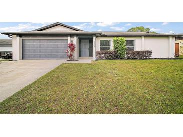 Charming single-story home featuring a well-maintained lawn, gray two car garage door, and attractive curb appeal at 5334 Mary Ann Ln, Orlando, FL 32810