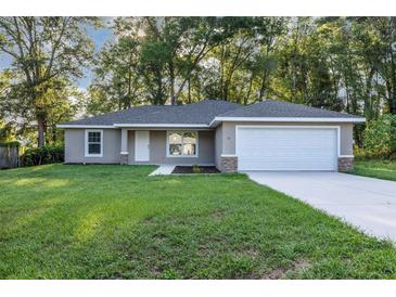 Charming single-story home with a well-manicured lawn and attached two car garage at 57 Pine Trace Crse, Ocala, FL 34472