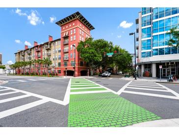 A vibrant street corner shows the property's colorful facade and crosswalks under a bright blue sky at 911 N Orange Ave # 541, Orlando, FL 32801