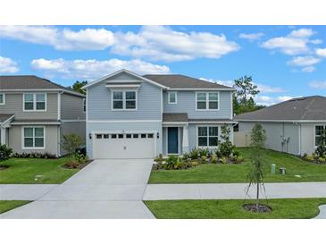 Charming two-story home boasts a well-manicured lawn and attached two car garage at 9763 Brown Burrow St, Orlando, FL 32829