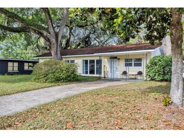 Charming home with a well-maintained lawn and mature trees providing shade and curb appeal at 112 E Coleman Cir, Sanford, FL 32773