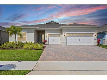 Charming single-story home with a three-car garage, paver driveway, and beautifully landscaped front yard at 13133 Sunny Retreat Ln, Winter Garden, FL 34787