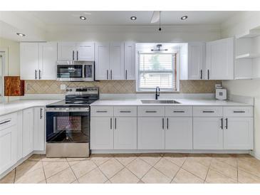 Bright kitchen featuring white cabinetry, stainless steel appliances, and updated countertops at 1624 Bel Air Ave, Orlando, FL 32812