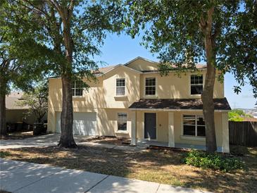 Inviting two-story home with a two-car garage and mature trees enhancing the curb appeal at 2018 Knollcrest Dr, Clermont, FL 34711