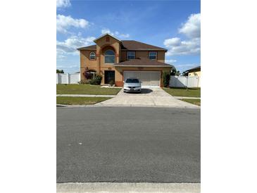 Charming two-story home featuring a spacious driveway and attached two car garage at 5406 Crepe Myrtle Cir, Kissimmee, FL 34758