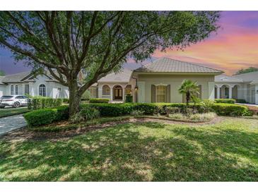 Well-maintained front yard with lush landscaping and a large shade tree enhancing the home's curb appeal at 6125 Foxfield Ct, Windermere, FL 34786