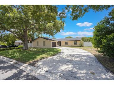 Charming single-story home features a circular driveway, lush landscaping, and mature trees for added curb appeal at 725 Laurel Way, Casselberry, FL 32707