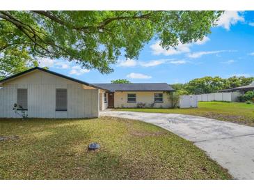 Charming single-story home featuring a long driveway and a well-maintained front yard with mature trees at 725 Laurel Way, Casselberry, FL 32707