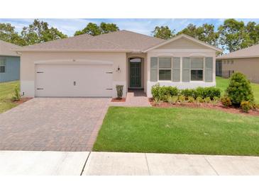 Charming single-story home boasts lush green lawn, brick driveway, and neutral exterior paint at 1511 Lyonsdale Ln, Sanford, FL 32771