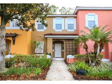Charming multi-colored townhome with a well-maintained lawn, blooming flowers and lush landscaping at 8487 Crystal Cove Loop, Kissimmee, FL 34747