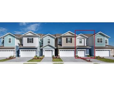 Charming townhome showcases a modern facade, two-car garage, and manicured front lawn at 1263 Stockwell Ave, St Cloud, FL 34771