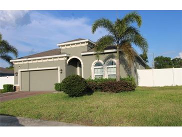 Beautiful single-story home features well-manicured lawn, two-car garage, and charming architectural details at 146 Loblolly Ln, Davenport, FL 33837