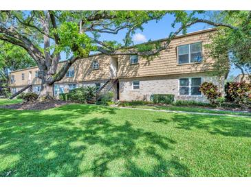 Charming condo building with lush lawn, mature trees, and manicured landscaping at 200 Saint Andrews Blvd # 1603, Winter Park, FL 32792