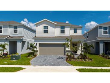 Charming two-story home with a paver driveway, attached two-car garage, and beautifully landscaped front yard at 3413 Lilac, Davenport, FL 33897