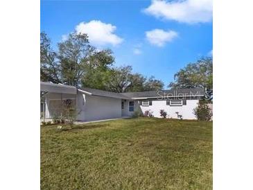 Charming single-story home with a well-manicured lawn and a carport, perfect for easy parking at 5144 Orange Ave, Winter Park, FL 32792
