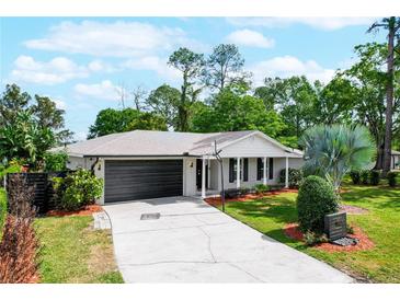 Charming single-story home featuring a well-manicured lawn, mature trees, and a two-car garage at 5301 Pineview Way, Apopka, FL 32703