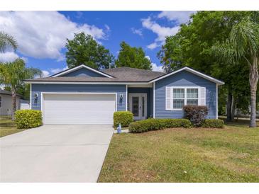Charming single-story home with blue siding, manicured lawn, and a two-car garage at 741 Mystic Oaks Ln, Deland, FL 32724