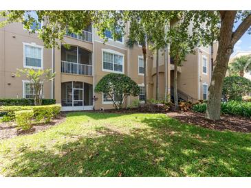 Beautiful condo exterior view showing manicured lawn and screened balcony at 7654 Comrow St # 104, Kissimmee, FL 34747