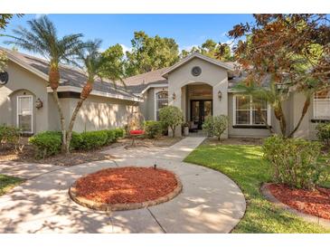 Charming home with lush landscaping, inviting entryway, and a hanging chair on the front porch at 1125 E Tuskawilla Pt, Winter Springs, FL 32708