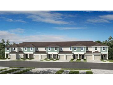 New townhome development with multi-car garages, sidewalk and neutral color scheme on a partly cloudy day at 180 River Front Way, Edgewater, FL 32141
