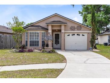 Charming single-story home featuring a well-manicured lawn, a bay window, and an attached garage at 428 Winding Oak Ln, Longwood, FL 32750