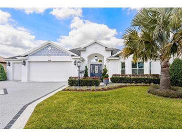 Charming single-story home with well-maintained lawn, lush landscaping, and a pristine three-car garage at 5896 Barclay Ct, The Villages, FL 32163
