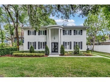 Stunning two-story home with elegant white columns, lush landscaping and black shutters at 613 Daniels Ave, Orlando, FL 32801