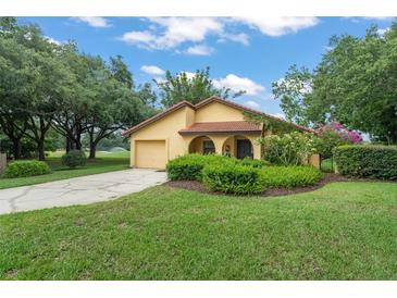 Charming yellow home with well-manicured lawn and landscaping at 6301 Parson Brown Dr, Orlando, FL 32819