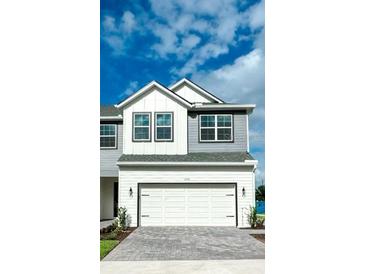 Charming two-story home with a white garage door and gray and white siding at 1533 Heritage Pl, Oviedo, FL 32765