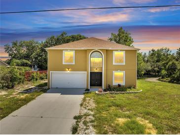 Charming two-story home boasting a large front yard, a two-car garage, and an arched entryway at 2004 Prescott Blvd, Deltona, FL 32738