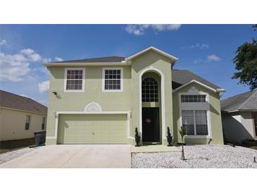 Charming two-story home featuring an arched entryway and an attached two-car garage at 339 Sigmund Loop, Davenport, FL 33837
