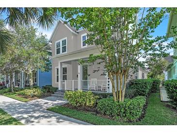 Charming two-story home with a cozy front porch, lush landscaping, and inviting curb appeal on a sunny day at 8340 Laureate Blvd, Orlando, FL 32827