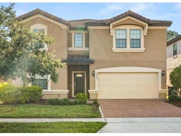 Two-story home featuring a two-car garage and neutral stucco exterior with well-maintained landscaping at 8828 Bengal Ct, Kissimmee, FL 34747