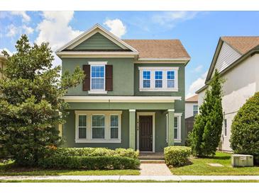 Charming two-story home with green exterior, brown shutters, manicured lawn, and inviting front porch at 14154 Shocklach Dr, Winter Garden, FL 34787