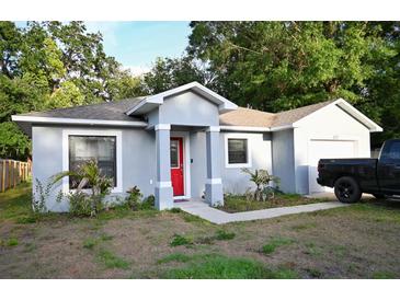 Charming single-story home with a bright red front door and an attached garage at 517 Walnut St, Auburndale, FL 33823