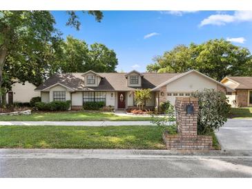 Charming single-story home with well-manicured lawn and mature trees in a quiet residential neighborhood at 1017 American Beauty St, Orlando, FL 32818