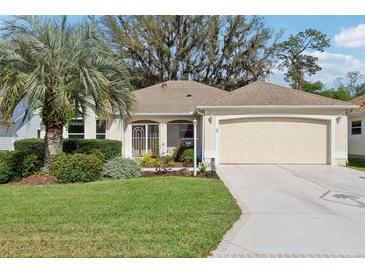 Charming single-story home boasts lush landscaping, well-manicured lawn, and an inviting front entrance at 1309 Carolina Ct, The Villages, FL 32162