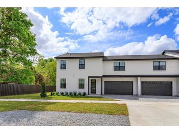 New construction townhome featuring a two-car garage, modern design, and landscaped front yard at 1340 Crystal Lake E Ave, Orlando, FL 32806