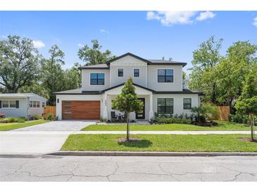 Beautiful two-story home with modern wood garage door and manicured front yard at 2306 Hargill Dr, Orlando, FL 32806