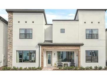 Modern two-story home featuring a stylish facade, covered entryway, and carefully landscaped front yard at 235 Villa Domani Cir, Davenport, FL 33896
