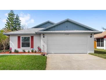 Charming single-story home with a two-car garage, red shutters, and well-manicured front lawn at 3192 Running Deer Path, Kissimmee, FL 34746