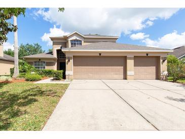 Charming two-story home with a three car garage and a well maintained front yard at 341 Kirkhill St, Ocoee, FL 34761