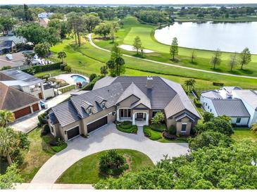 Stunning aerial view of a luxury estate with a pool, golf course, and lake access at 5640 Brookline Dr, Orlando, FL 32819