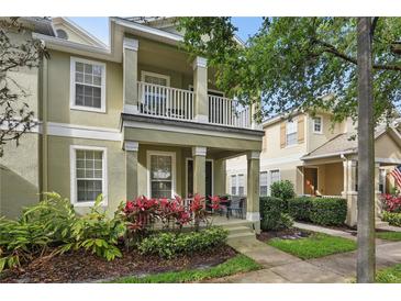 Inviting townhome featuring a porch with decorative landscaping and a second-story balcony at 7130 Forty Banks Rd, Harmony, FL 34773