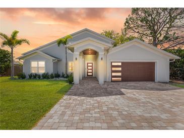 Charming single-Gathering home featuring modern architecture, a well-manicured lawn, and a brick-paved driveway at 8616 Port Said St, Orlando, FL 32817