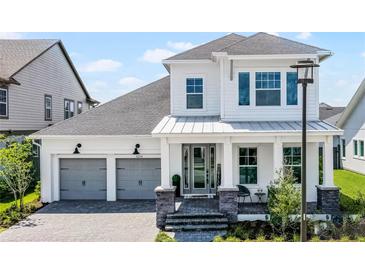 Charming two-story home featuring a two-car garage, inviting front porch, and meticulously landscaped front yard at 9250 Neher St, Orlando, FL 32827