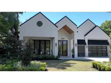 Stunning home showcasing a modern design with a white brick facade and well-manicured lawn at 1220 Delaney Park Dr, Orlando, FL 32806