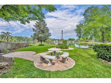 Inviting backyard with a stone picnic table and peaceful lake view, perfect for outdoor dining and relaxation at 1329 Maury Rd, Orlando, FL 32804